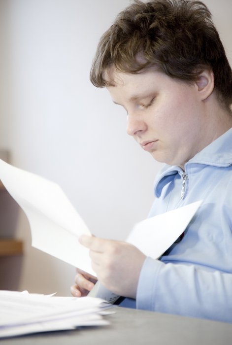 Werkstattbeschäftigter sortiert Papier Werkstattbeschäftigter sortiert Papier